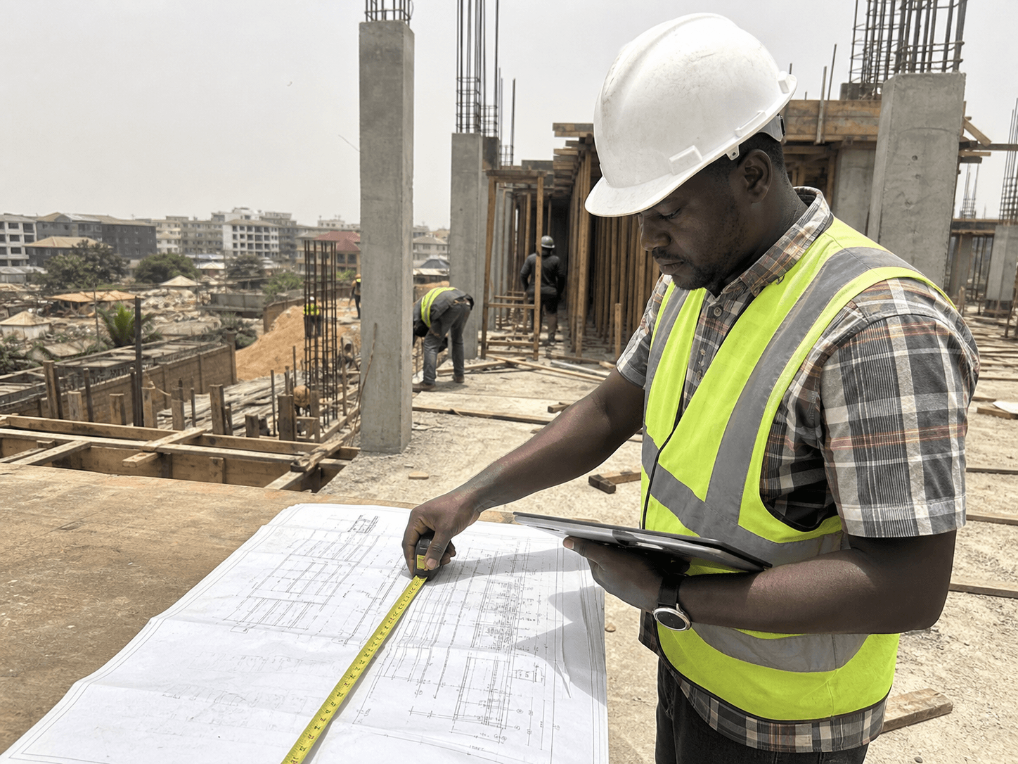 Ghanaian construction team reviewing live project information on a tablet